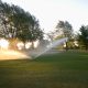 Watering the golf course very early in the morning.